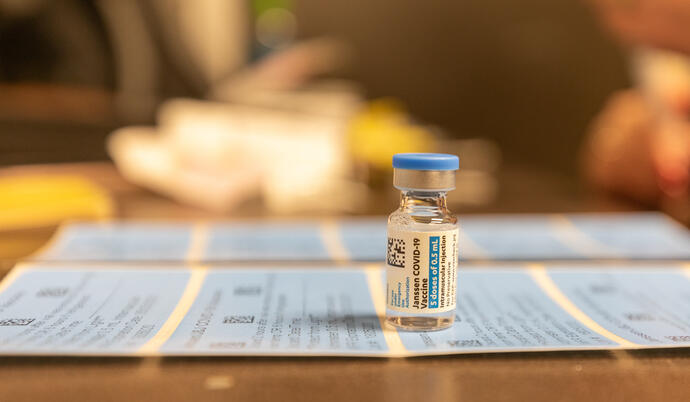 vile of covid vaccine placed on top of medical paper work